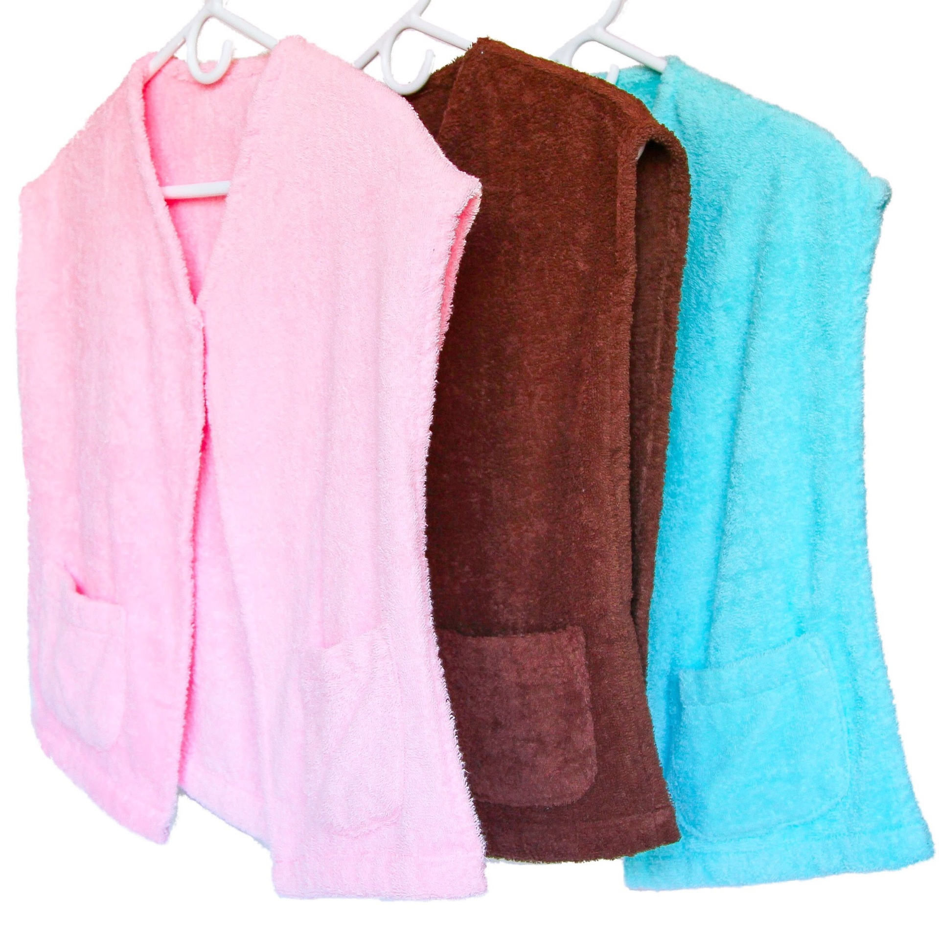 Pink, chocolate, and cyan La Capelette capes hanging together.